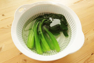 冷水を張ったボウルで冷やしているゆでた小松菜。