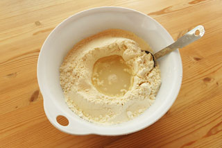 くぼみをつけた小麦粉に塩水を注ぐ。