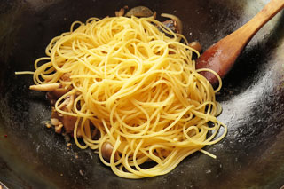 サバ缶パスタのソースの入ったフライパンにゆでたスパゲティを入れる
