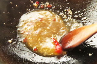 パスタソースを作っているフライパンにスパゲティのゆで汁を入れてかき混ぜる