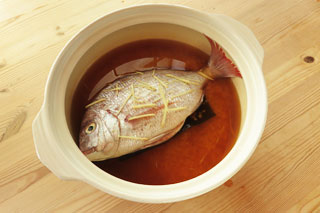土鍋に米と昆布、鯛を入れた炊く前の鯛めし。