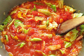 フタをして蒸し煮にしたキャベツとトマト缶の中身を煮る。