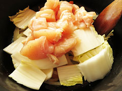 玉ねぎとにんじんを炒めている鍋に、鶏胸肉と白菜の芯を入れる。